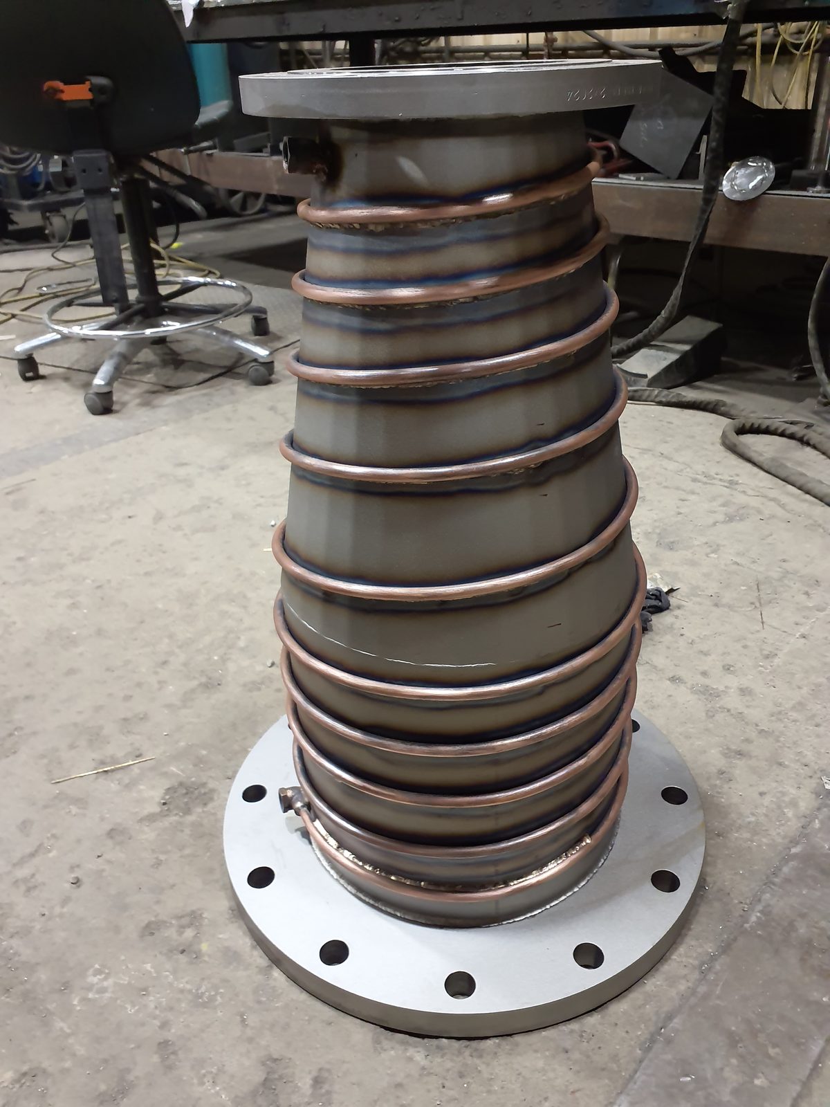 Welded conical steel assembly with tubing coil and drilled flange